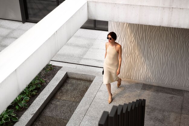 Retrato de mujer rica al aire libre con elegante vestido y gafas de sol