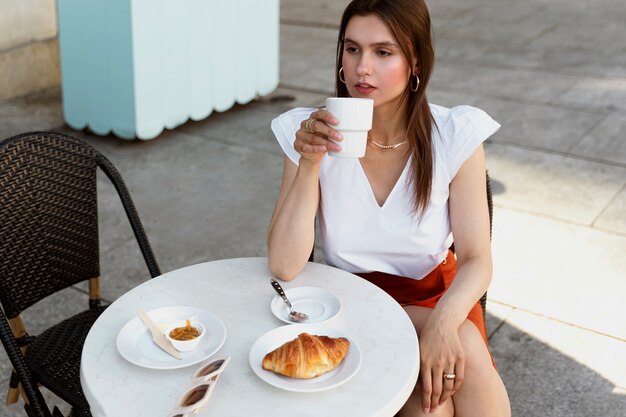 Retrato de mujer rica tomando un café