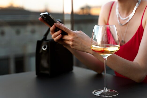 Retrato de mujer rica con vino y teléfono inteligente