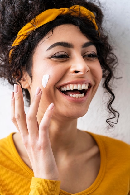 Foto gratuita retrato de mujer riendo y jugando con crema hidratante