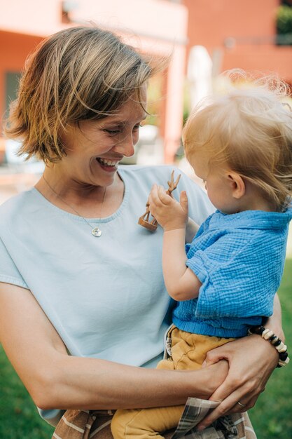 Retrato de mujer riendo sosteniendo a su hijo