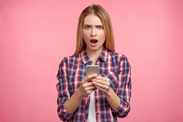Retrato de mujer rubia en camisa a rayas con teléfono