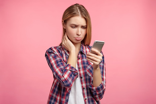 Retrato de mujer rubia en camisa a rayas con teléfono