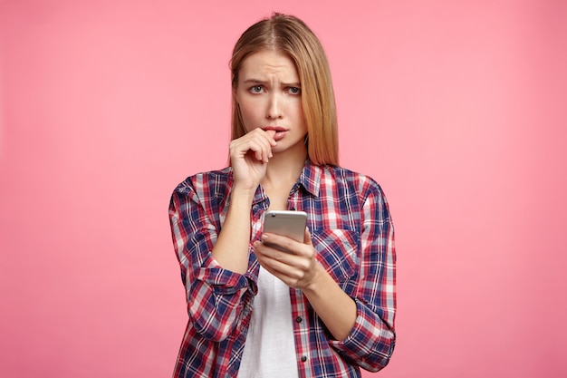 Retrato de mujer rubia en camisa a rayas con teléfono