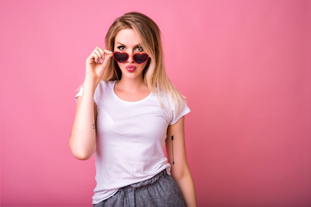 Retrato de mujer rubia hipster posando en rosa