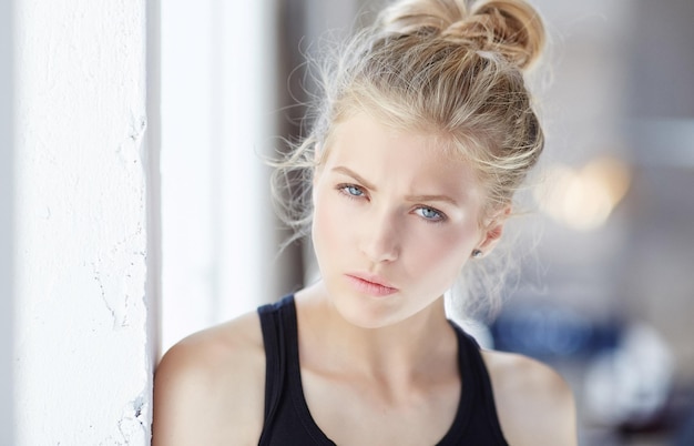 Retrato de mujer rubia con maquillaje claro y ojos azules.