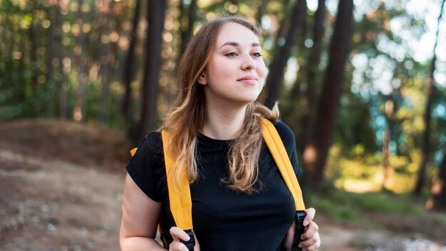 Foto gratuita retrato de mujer rubia con mochila en el bosque