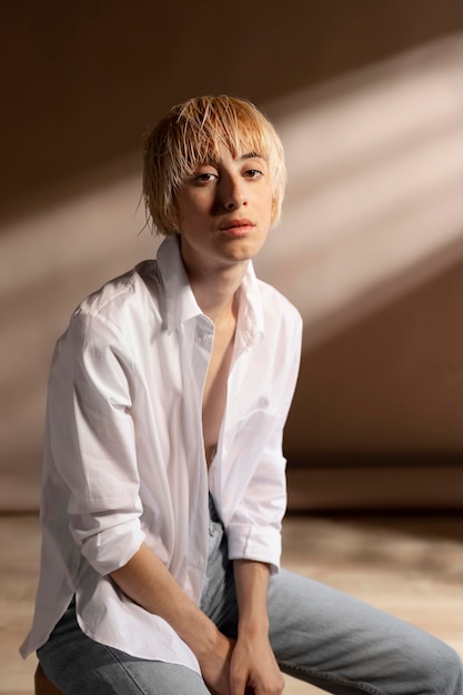 Retrato de mujer rubia de pelo corto posando con una camisa blanca