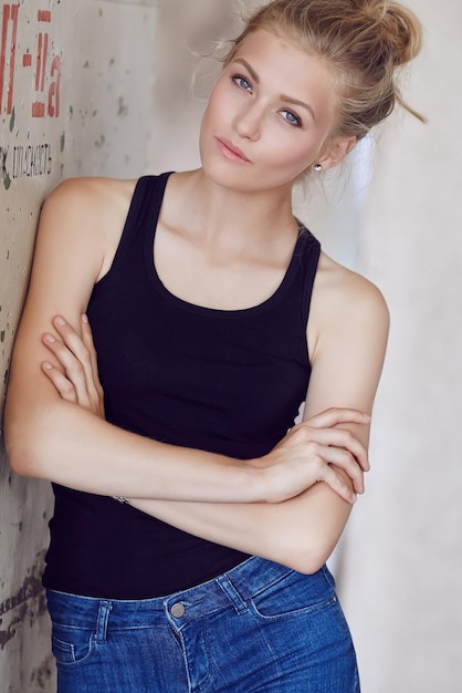 Retrato de mujer rubia en shorts de jeans y camisa negra.