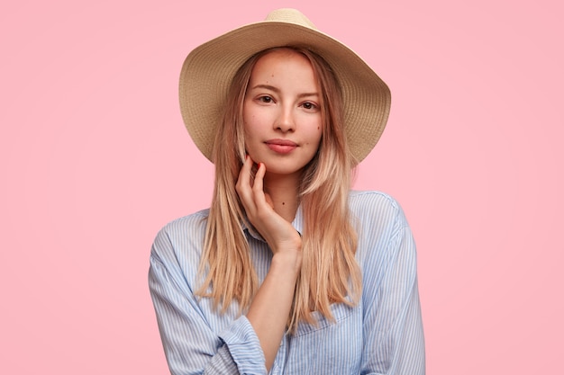 Retrato de mujer rubia con sombrero de paja grande posando