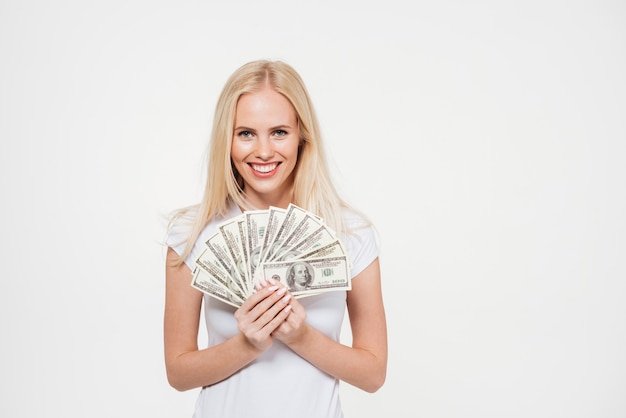 Retrato de una mujer satisfecha feliz con montón de dinero