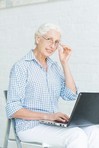 Retrato de mujer senior feliz con portátil