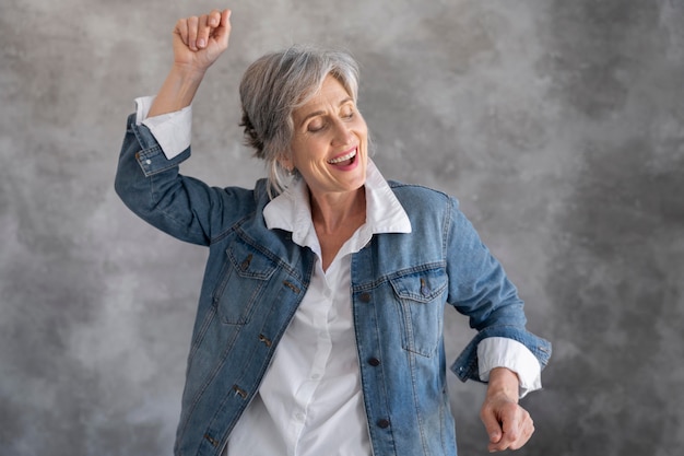 Retrato de mujer senior sonriente en chaqueta de jean