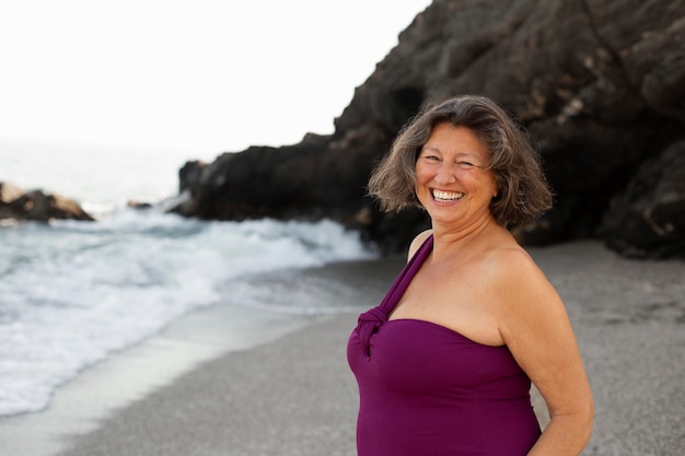 Retrato de mujer senior sonriente en la playa.