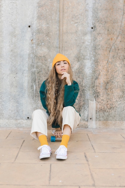 Foto gratuita retrato mujer sentada en patineta