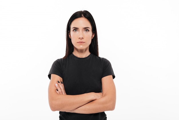 Retrato de una mujer seria de pie con los brazos cruzados