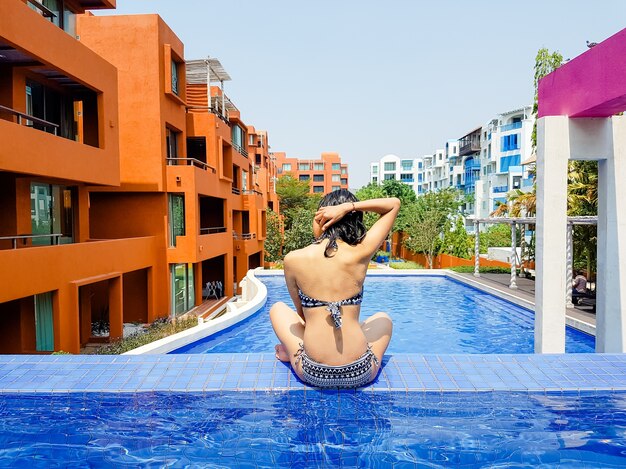 Retrato de mujer sexy alegre relajante en la piscina de lujo