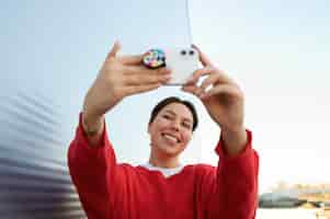 Foto gratuita retrato de mujer con smartphone con toma de corriente al aire libre