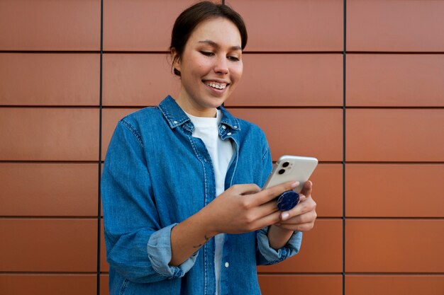 Retrato de mujer con smartphone con toma de corriente al aire libre