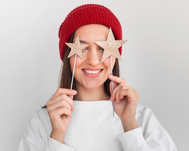 Retrato de mujer con sombrero sosteniendo adornos de estrellas