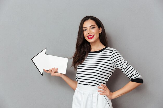 Retrato de una mujer sonriente apuntando lejos