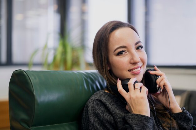 Retrato de mujer sonriente con auriculares alrededor del cuello