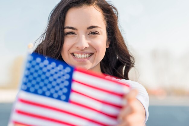 Retrato de mujer sonriente con bandera de Estados Unidos