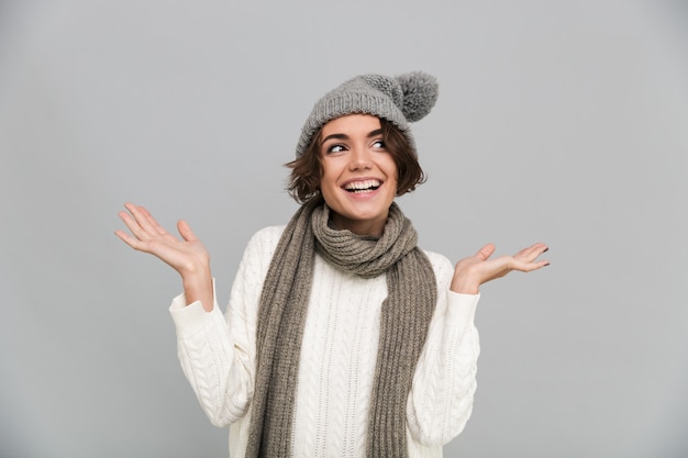 Retrato de una mujer sonriente en bufanda y sombrero posando