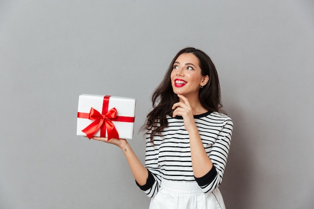 Retrato de una mujer sonriente con caja de regalo