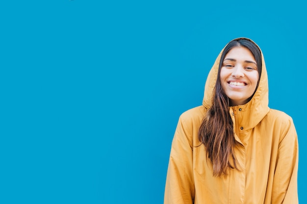 Retrato de mujer sonriente contra el fondo azul con espacio de copia