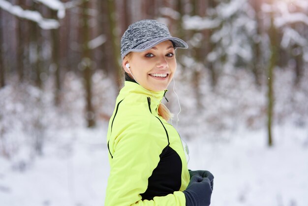 Retrato de mujer sonriente corriendo en invierno