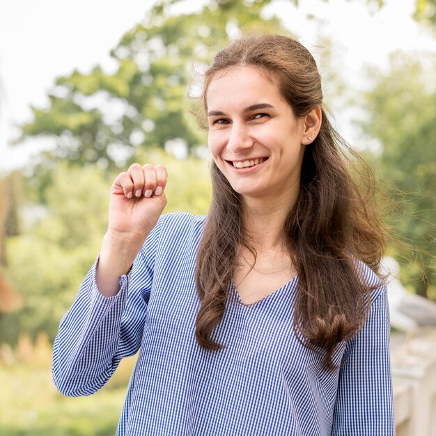 Retrato de mujer sonriente enseñando lenguaje de señas