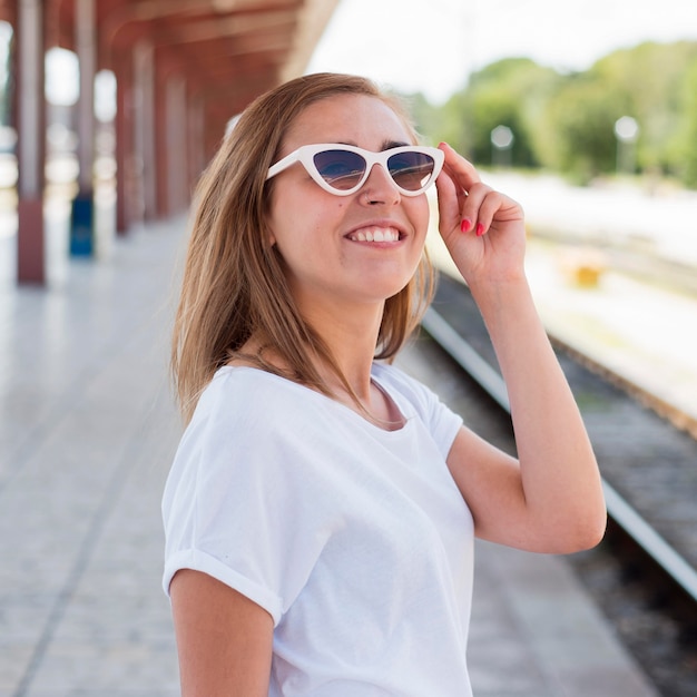 Foto gratuita retrato de mujer sonriente en la estación de tren