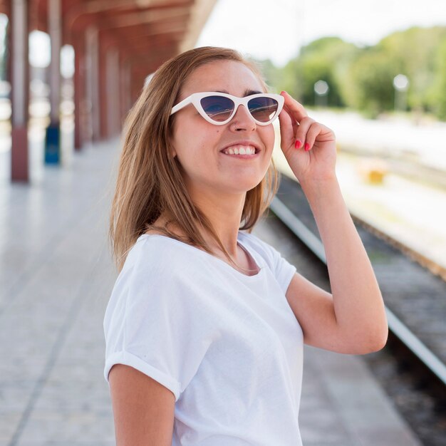 Retrato de mujer sonriente en la estación de tren