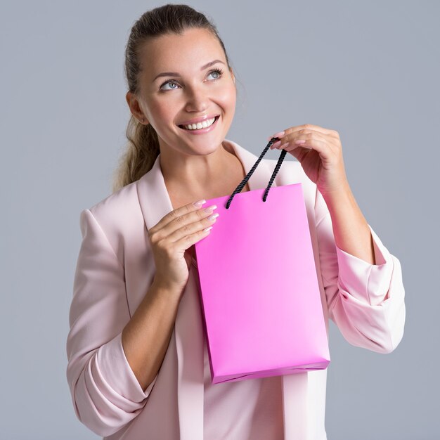 Retrato de una mujer sonriente feliz con bolsa rosa.