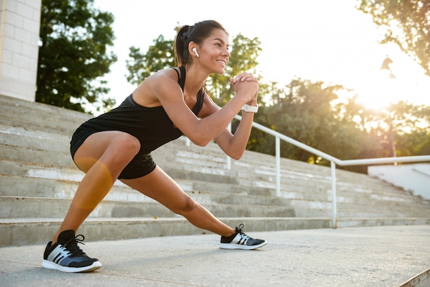 Retrato de una mujer sonriente de fitness en auriculares