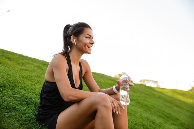 Retrato de una mujer sonriente de fitness en auriculares