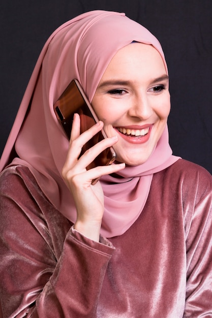 Retrato de mujer sonriente hablando por teléfono móvil