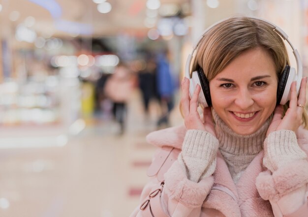 Retrato de mujer sonriente con heaphones en centro comercial