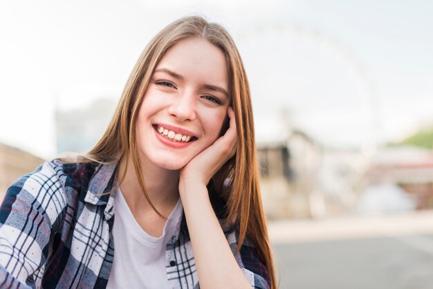 Retrato de la mujer sonriente joven hermosa que mira la cámara