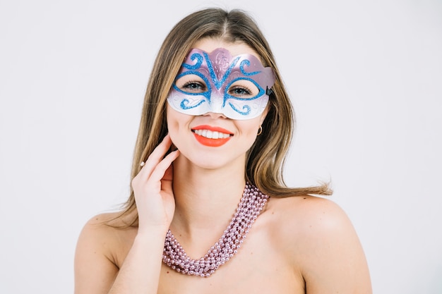Retrato de una mujer sonriente en máscara de carnaval con collar