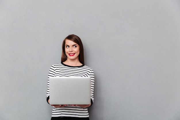 Foto gratuita retrato de una mujer sonriente con ordenador portátil