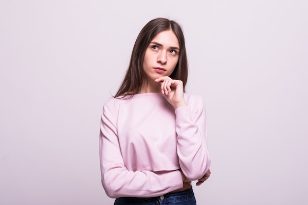 Retrato de una mujer sonriente pensando mirando hacia arriba aislado en blanco