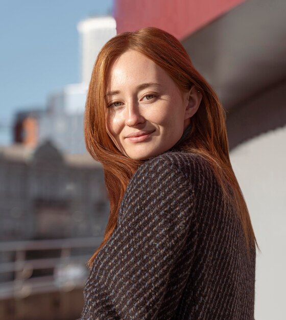 Retrato de mujer sonriente posando al aire libre