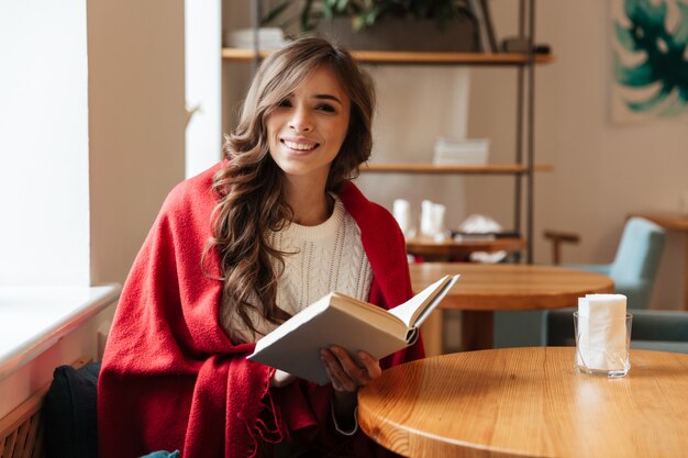 Retrato de una mujer sonriente que sostiene el libro