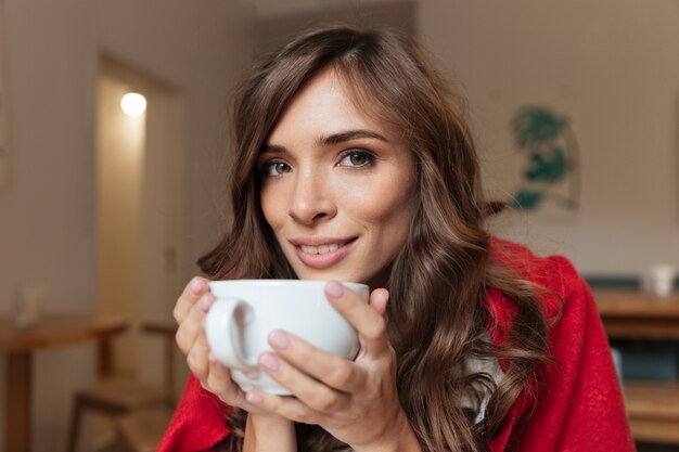 Retrato de una mujer sonriente que sostiene la taza