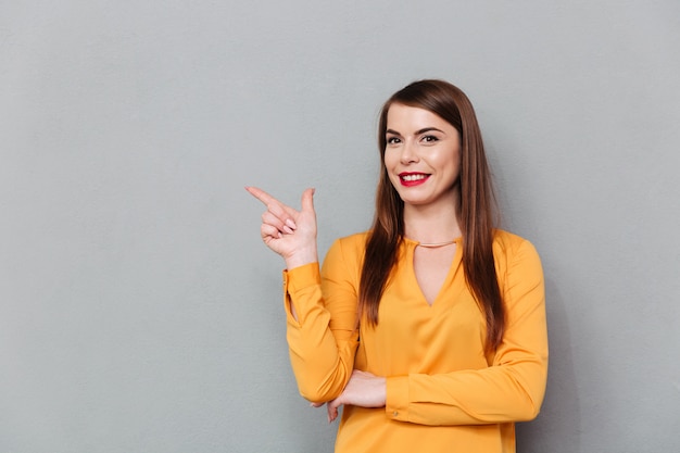 Retrato de una mujer sonriente señalando con el dedo