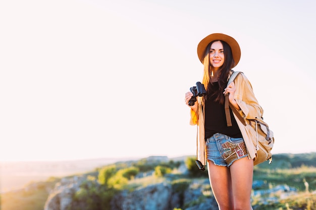 Retrato de una mujer sonriente sosteniendo binocular