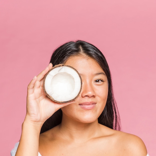 Retrato de mujer sonriente sosteniendo un coco