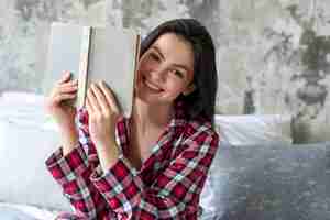 Foto gratuita retrato de mujer sonriente sosteniendo libro